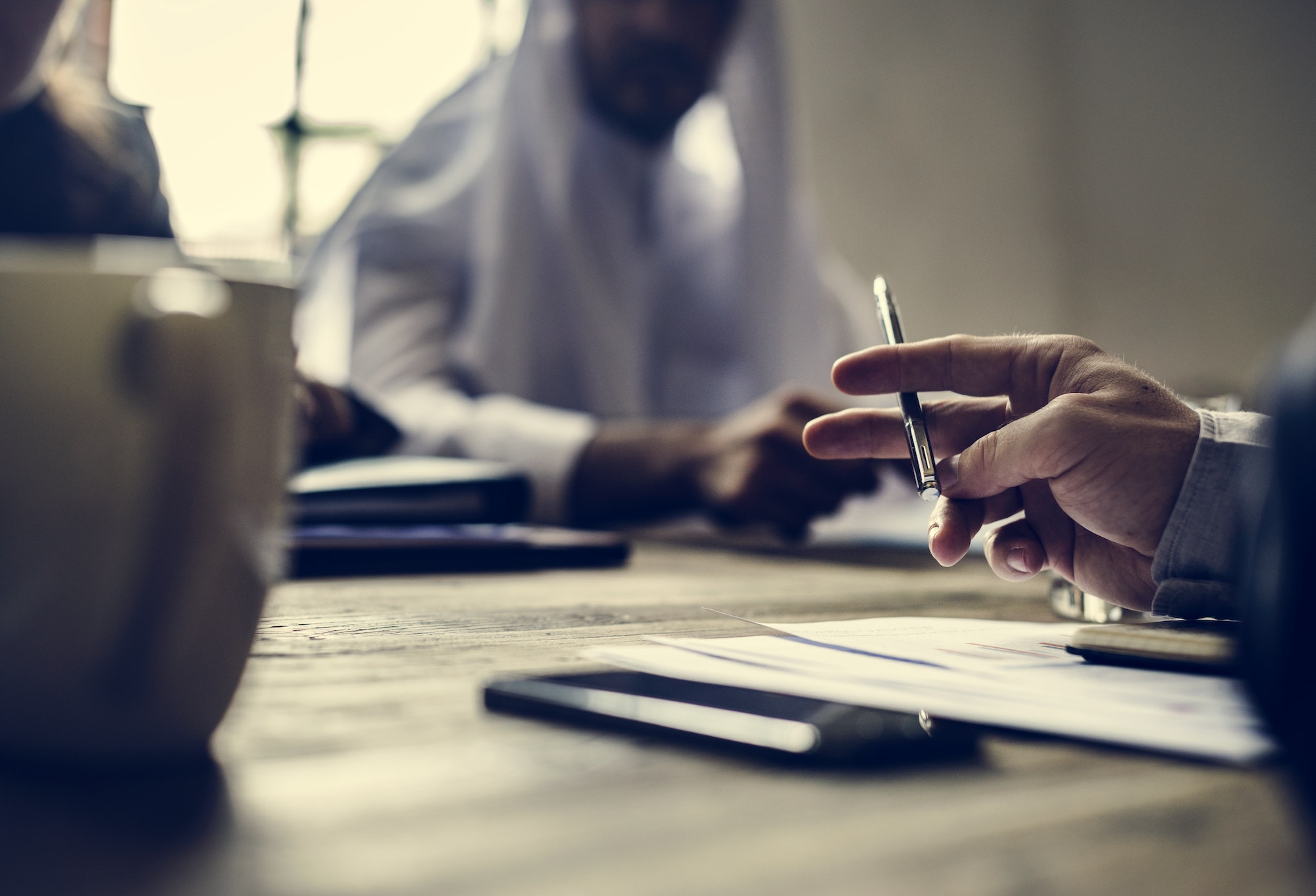 A St. Louis fraud lawyer providing legal advice to business clients at a desk.